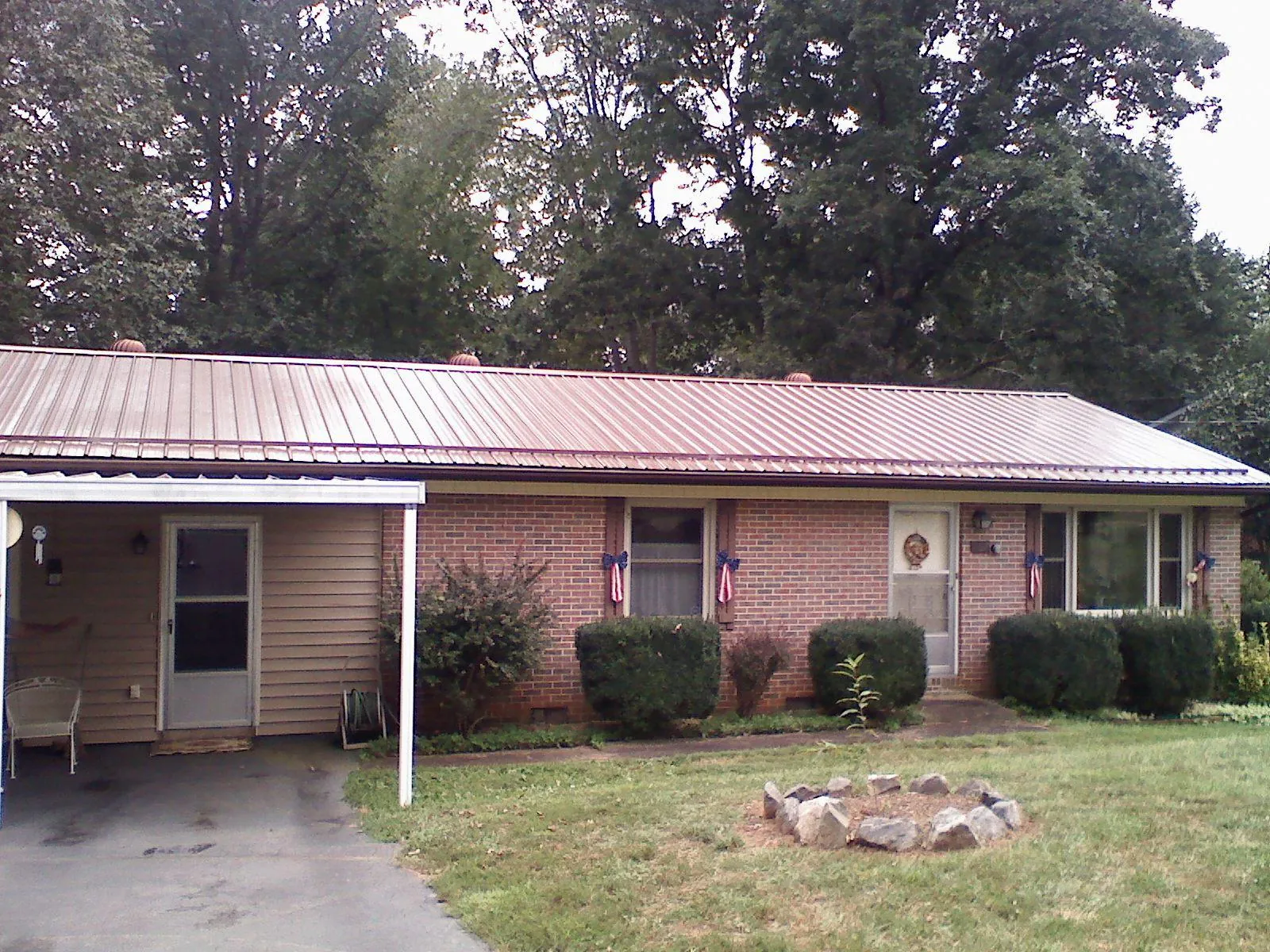 Bronze metal roof and carport on a brick ranch home — Roof Repair work by our crew in Lake Hamilton